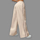 Beige wide-leg pants with a black stripe on a gray background